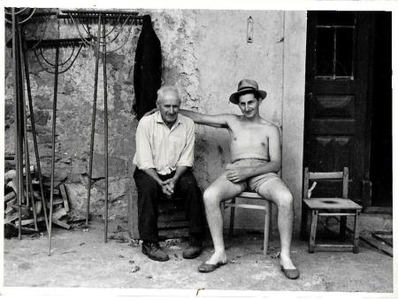 Oče Luka posega in sin Edo pred domačo hišo, pozna šesdeseta